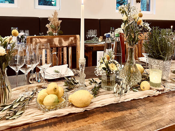 Tischdekoration mit Zitronen, Olivenzweige, Rosmarin